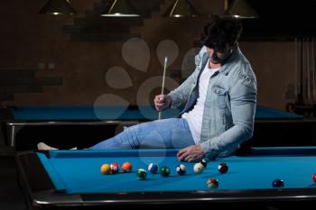Young Man Looking Confused At Billiard Table - He Is Losing