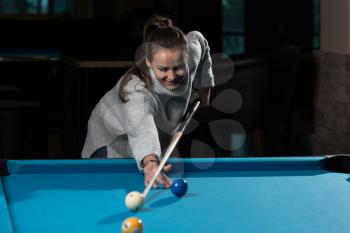 Young Woman Playing Billiards Lined Up To Shoot Easy Winning Shot