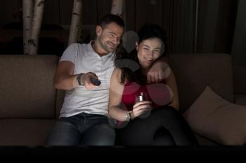 Young Heterosexual Couple Hugging on Sofa and Watching Movie on Tv at Home