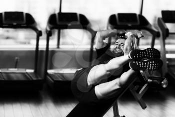 Young Fitness Man Working Out Abs On Adjustable Bench In Fitness Center
