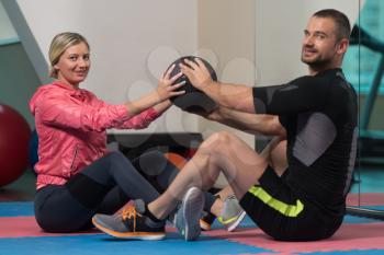 Young Couple Train Together With Ball A Abs Exercise In A Health And Fitness Concept