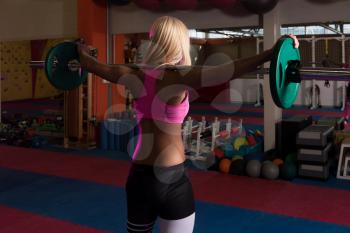 Fitness Woman Performing Barbell Squats - One Of The Best Bodybuilding Exercise For Legs