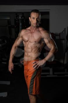Handsome Mature Man Standing Strong In The Gym And Flexing Muscles - Muscular Athletic Bodybuilder Fitness Model Posing After Exercises