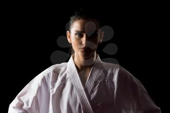 Young Muslim Woman In Traditional Kimono Practicing Her Karate Moves - Isolated On Black Background