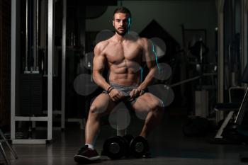 Good Looking And Attractive Young Athlete With Muscular Body Sitting On Bench And Relaxing In Gym