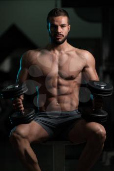 Good Looking And Attractive Young Athlete With Muscular Body Sitting On Bench And Relaxing In Gym