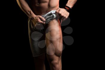 Young Athlete Flexing Leg Muscles - Isolate On Black Blackground - Copy Space