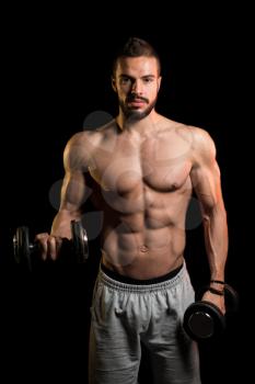 Young Man Working Out Biceps With Dumbbells On Black Background - Dumbbell Concentration Curls