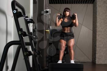Woman Working Out Legs On Machine In A Gym - Leg Exercise