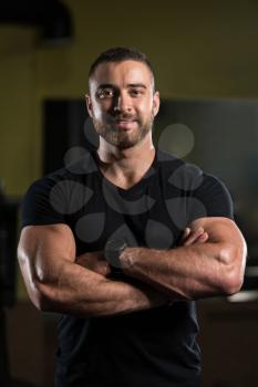 Portrait Of A Young Physically Fit Man Showing His Well Trained Body In Black Shirt - Muscular Athletic Bodybuilder Fitness Model Posing After Exercises
