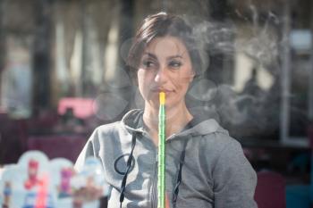 Young Woman Smoking Shisha Outdoors - Female Exhaling Smoke Inhaling From A Hookah
