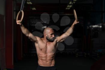 Adult Man Exercising While Holding Large Gymnastic Rings At The Gym