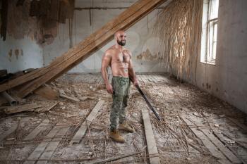 Action Hero Muscled Man Holding Machine Gun - Standing In Abandoned Building Wearing Army Pants