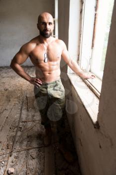 Portrait of a Physically Fit Man Showing His Well Trained Body - Muscular Athletic Bodybuilder Fitness Man Posing After Exercises Inside Shelter
