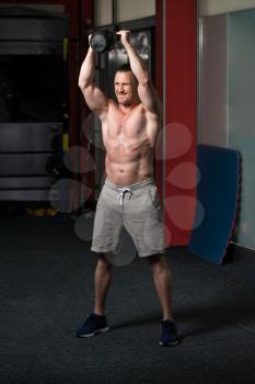 Young Man Exercising With Kettle Bell And Flexing Muscles - Muscular Athletic Bodybuilder Fitness Model Exercises