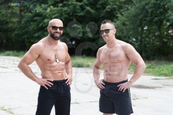 Portrait Of A Physically Fit Couple Showing They Well Trained Body - Muscular Athletic Bodybuilder Fitness Model Posing After Exercises