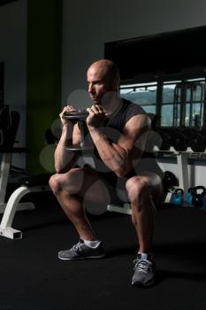 Strong Man In The Gym Exercising Hamstrings With Dumbbells - Muscular Athletic Bodybuilder Fitness Model Exercise