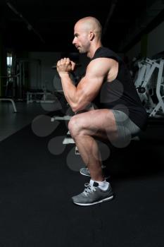 Strong Man In The Gym Exercising Hamstrings With Dumbbells - Muscular Athletic Bodybuilder Fitness Model Exercise