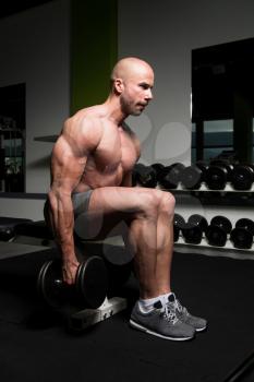 Serious Bodybuilder Doing Heavy Weight Exercise For Trapezius With Dumbbells