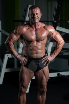 Portrait Of A Mature Physically Fit Man Showing His Well Trained Body - Muscular Athletic Bodybuilder Fitness Male Posing After Exercises