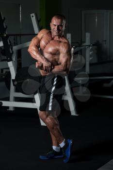 Healthy Mature Man Standing Strong In The Gym And Flexing Muscles - Muscular Athletic Bodybuilder Fitness Male Posing After Exercises