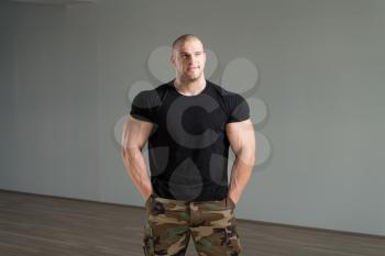 Healthy Man Standing Strong In Army Pants And Flexing Muscles - Muscular Athletic Bodybuilder Fitness Model Posing After Exercises