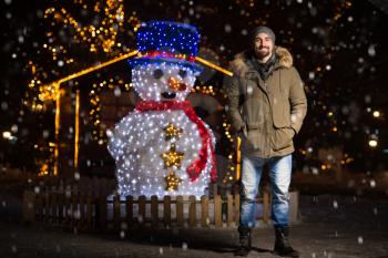Having Fun at a Christmas Fairy - Young Cheerful Man Dressed Warm Is Standing In Holiday Market