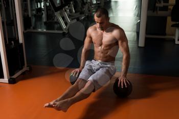Athlete Doing Handstand Push-Ups On Medicine Ball As Part Of Bodybuilding Training In Gym