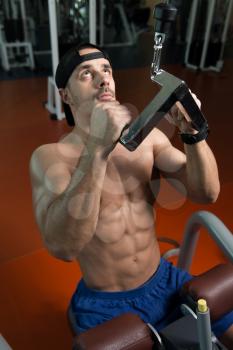 Handsome Athlete Doing Heavy Weight Exercise For Back On Machine In Gym