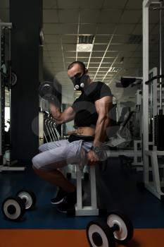 Athlete Working Out Biceps In Elevation Mask - Dumbbell Concentration Curls