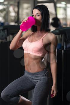 Attractive Women Resting After Exercise And Drinking From Shaker