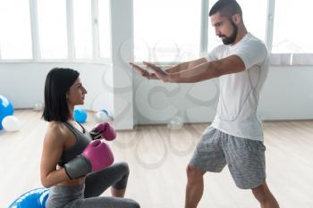 Woman Boxer MMA Fighter Practice Her Skills With Personal Trainer In Gym