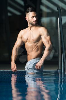 Young Healthy Good Looking Macho Man Model Athlete At Hotel Indoor Pool