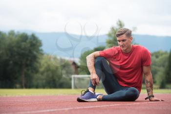 Young Athlete Man Relax and Strech Ready for Run at Athletics Race Track on Stadium