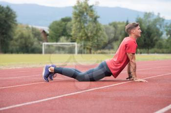 Young Athlete Man Relax and Strech Ready for Run at Athletics Race Track on Stadium