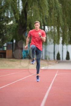 Sporty Man Running Fitness Workout on Track Exercising Outside