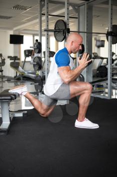 Strong Man In The Gym Exercising Legs With Dumbbells - Muscular Athletic Bodybuilder Fitness Model Exercise