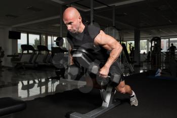 Serious Bodybuilder Doing Heavy Weight Exercise For Trapezius or Back With Dumbbells
