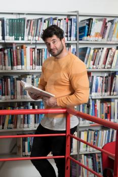 Handsome Man With Dark Hair Standing in the Library - Student Preparing Exam and Learning Lessons in School Library