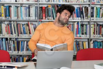 Portrait of an Attractive Student Doing Some School Work With a Laptop in the Library