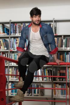 In the Library - Handsome Male Student With Books Working in a High School - University Library - Shallow Depth of Field