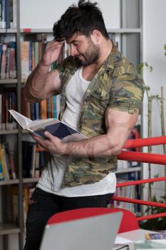 Athletic Fitness Male Student With Books Working in a High School Library