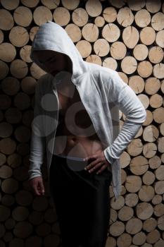 Healthy Young Man Standing Strong Standing Against a Wall and Flexing Muscles In Sweatshirt - Muscular Athletic Bodybuilder Fitness Model Posing After Exercises - a Place for Your Text