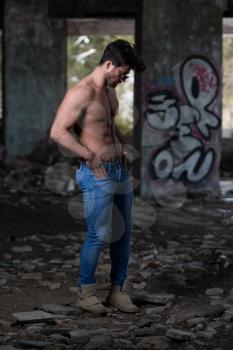 Portrait of a Young Physically Fit Man Showing His Well Trained Body - Muscular Athletic Bodybuilder Fitness Model Posing After Exercises In Front Of A Graffiti Wall