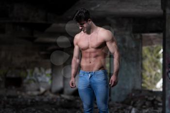 Portrait of a Young Physically Fit Man Showing His Well Trained Body - Muscular Athletic Bodybuilder Fitness Model Posing After Exercises In Front Of A Graffiti Wall