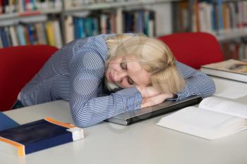 In the Library Pretty Female Student With Books Sleeping in a High School - University Library - Shallow Depth of Field