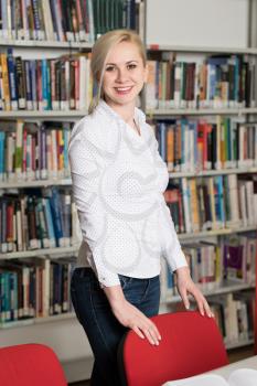 In the Library - Pretty Female Student With Books Working in a High School - University Library - Shallow Depth of Field