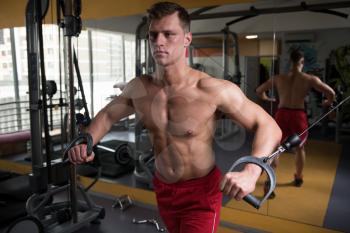 Muscular Man Doing Heavy Weight Exercise For Chest On Machine With Cable In The Gym