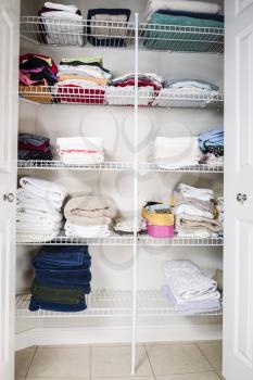 clean and organized bathroom closet with towels on shelves