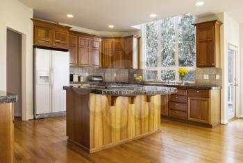 Modern Kitchen with Red Oak wooden floors, center gas stove island with stone counter tops and Daylight coming from large Vertical Windows